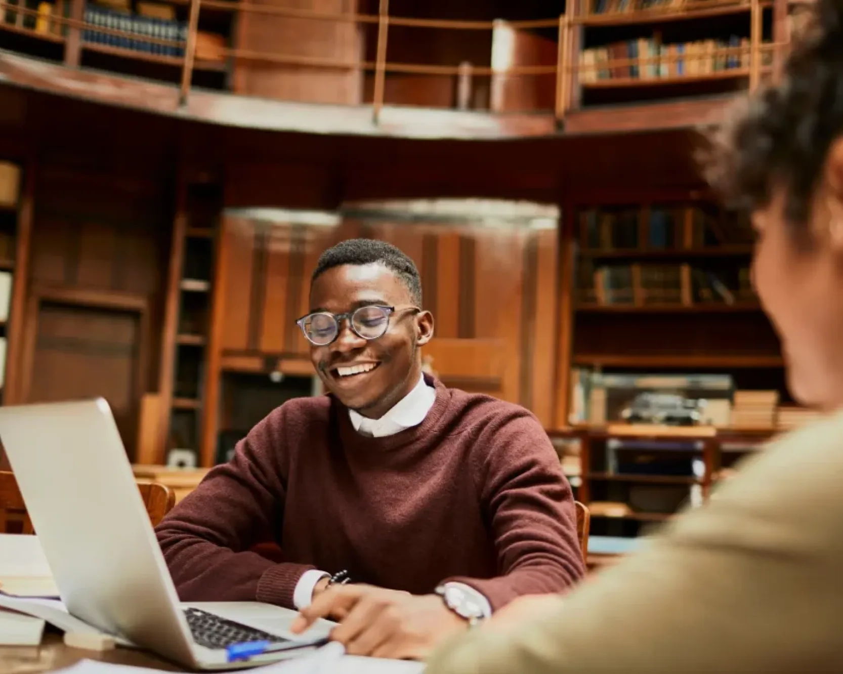A law student working on a laptop in a library